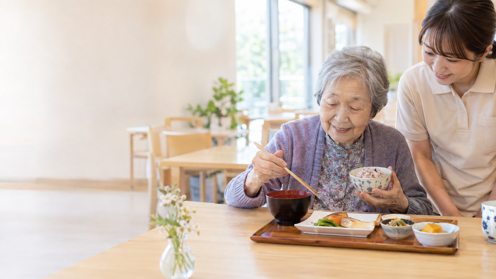 高齢者施設で食事を楽しむ利用者とスタッフ